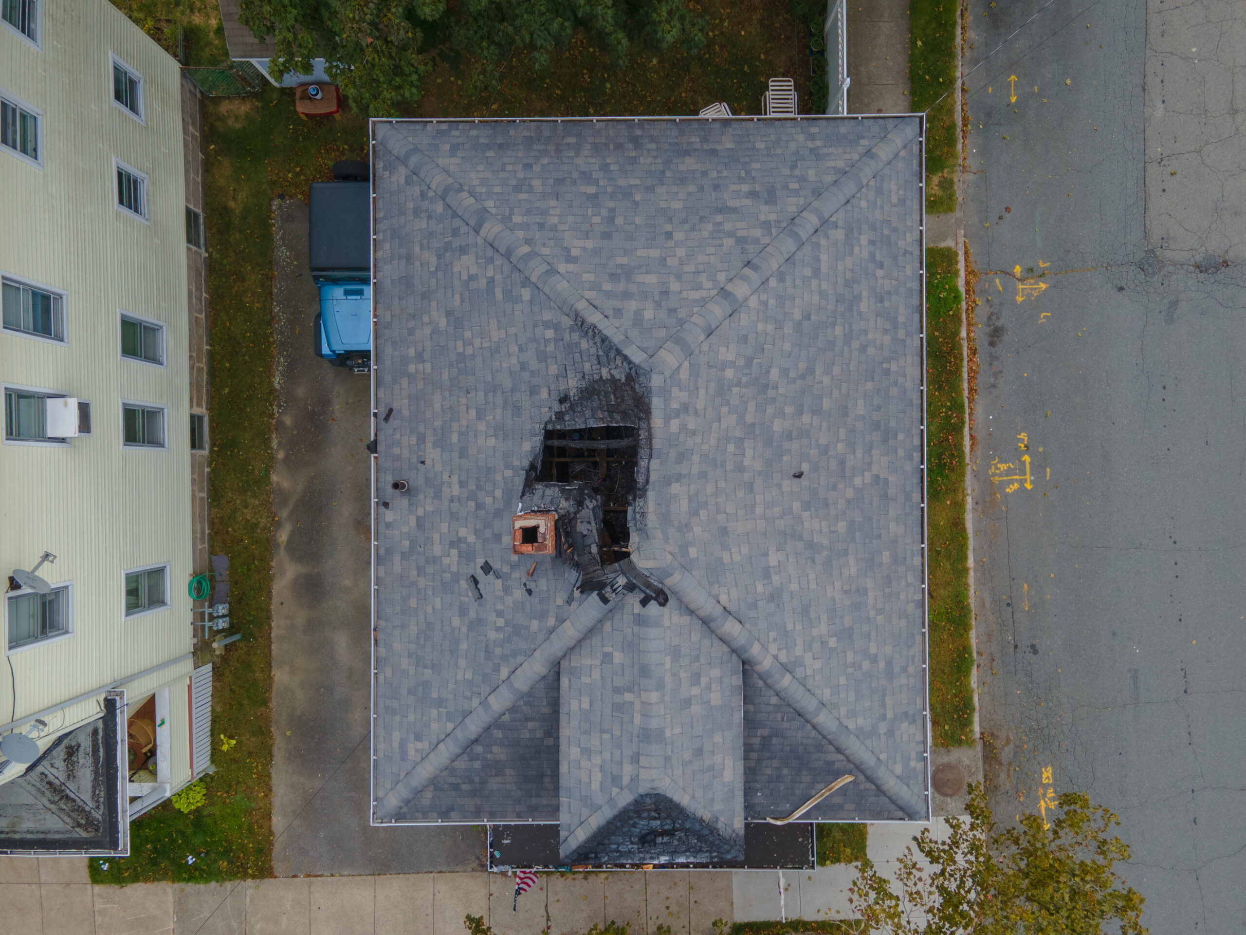 Aerial Top-Down View of Fire-Damaged Residential Roof After House Fire