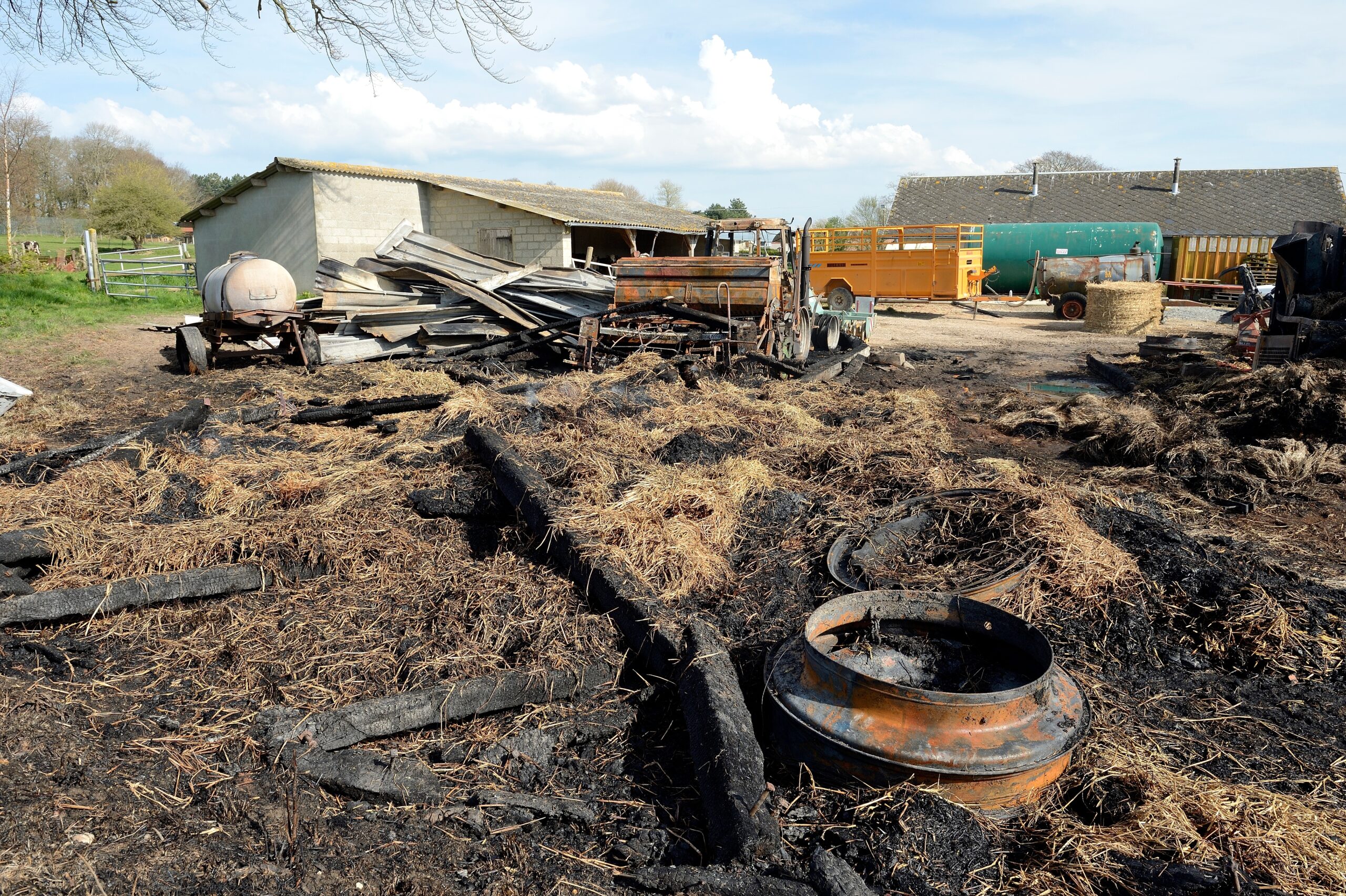 Incendie dans un batiment agricole provoqué par un acte de malveillance. Destruction totale du batiment, de la paille et du lin ainsi que de matériel agricole (tracteur, semoir, enrouleuse, herse, etc...) Experts assurances, gendarme et agriculteur en train de constater les dégats. Ouverture d'une enquête